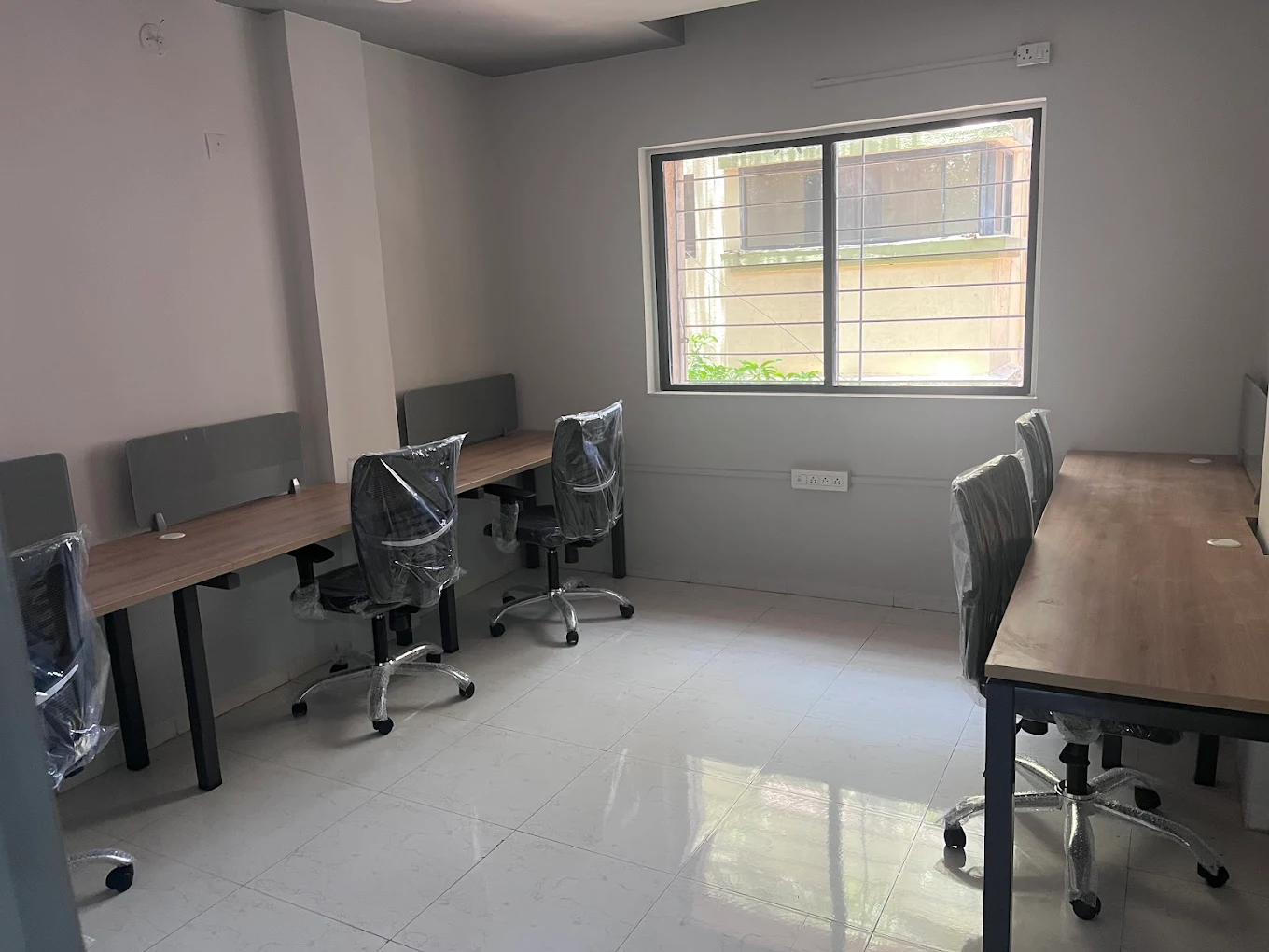 Open coworking desk area with natural light at Pithika